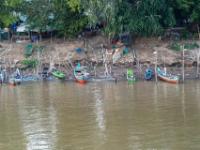 Kleine Boote vertäut an Stangen am Mekong Flußufer - Kambodscha